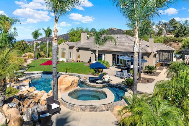 view of pool with an in ground hot tub, a patio area, and a lawn