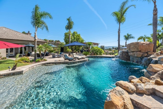 view of pool with pool water feature and a patio