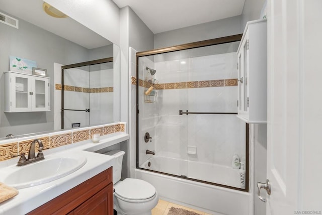 full bathroom with tile patterned flooring, vanity, toilet, and bath / shower combo with glass door