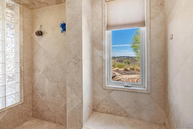 bathroom featuring a wealth of natural light and tiled shower