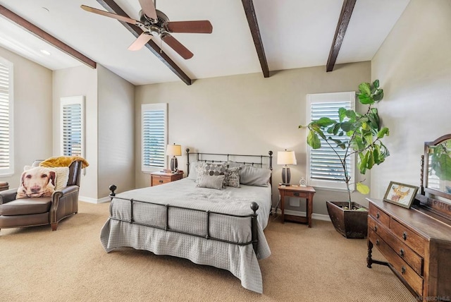 carpeted bedroom featuring beamed ceiling and ceiling fan