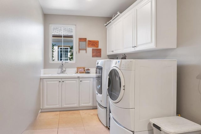 clothes washing area featuring cabinets, independent washer and dryer, light tile patterned floors, and sink