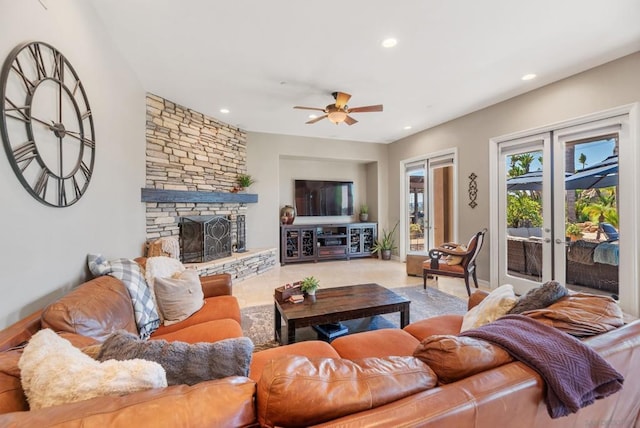 living room featuring ceiling fan, a fireplace, and french doors