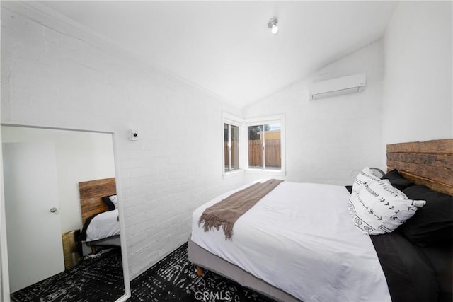 bedroom featuring brick wall, lofted ceiling, and a wall unit AC