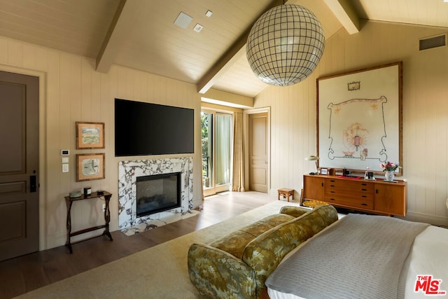 bedroom featuring access to exterior, a high end fireplace, wooden walls, dark hardwood / wood-style floors, and vaulted ceiling with beams