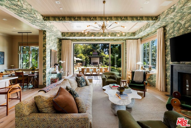 living room featuring light wood-type flooring, a chandelier, and a healthy amount of sunlight