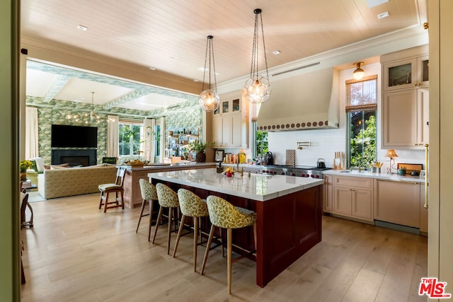 kitchen with light stone countertops, a center island, wooden ceiling, light hardwood / wood-style floors, and a breakfast bar area