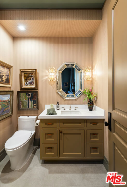 bathroom featuring toilet, vanity, and concrete floors