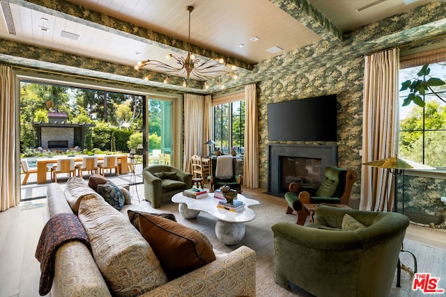 living room with beam ceiling, a chandelier, hardwood / wood-style floors, and wooden ceiling