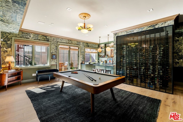 game room with billiards, a notable chandelier, light wood-type flooring, and ornamental molding