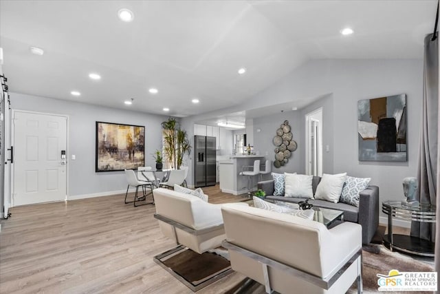 living room featuring vaulted ceiling and light hardwood / wood-style floors