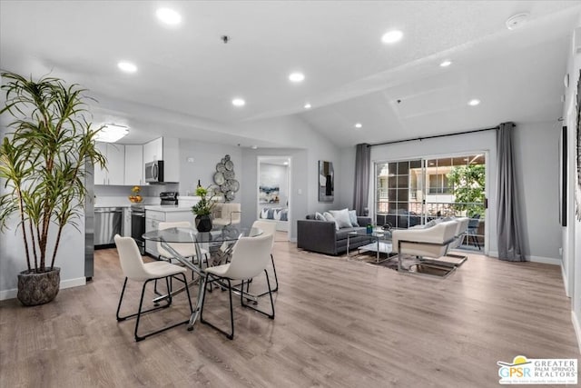 dining room with lofted ceiling and light wood-type flooring