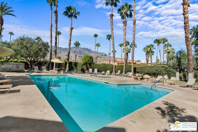 view of swimming pool with a mountain view and a patio