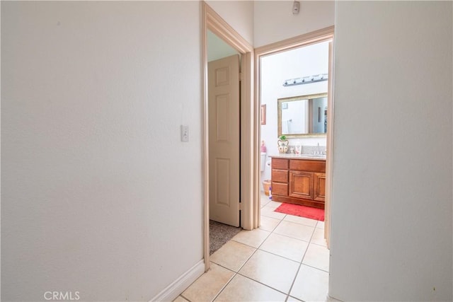 hall with sink and light tile patterned flooring