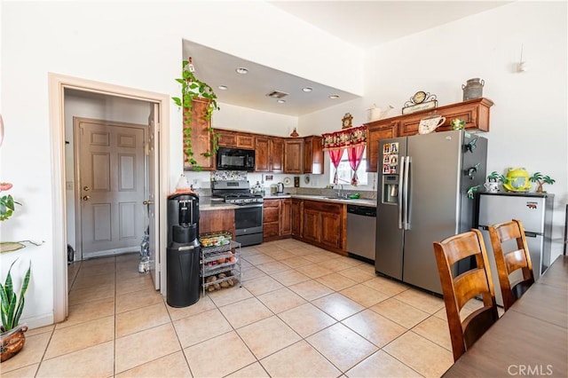 kitchen featuring sink, light tile patterned floors, and stainless steel appliances