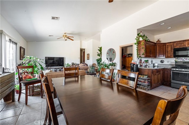 dining space featuring ceiling fan, light tile patterned flooring, and lofted ceiling