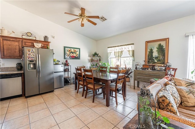 dining room featuring ceiling fan, light tile patterned flooring, and lofted ceiling