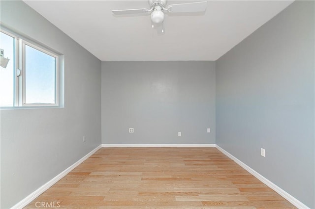 empty room with ceiling fan and light hardwood / wood-style flooring