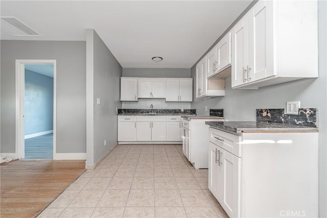 kitchen with sink, white cabinets, and light hardwood / wood-style floors