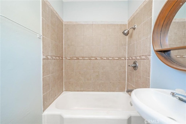 bathroom with tiled shower / bath and sink