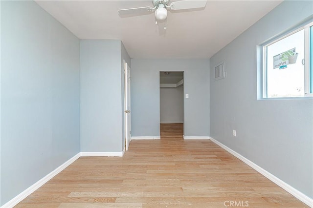 interior space with ceiling fan, light wood-type flooring, a spacious closet, and a closet