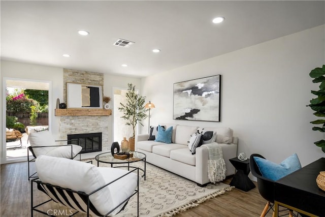 living room featuring hardwood / wood-style floors and a stone fireplace