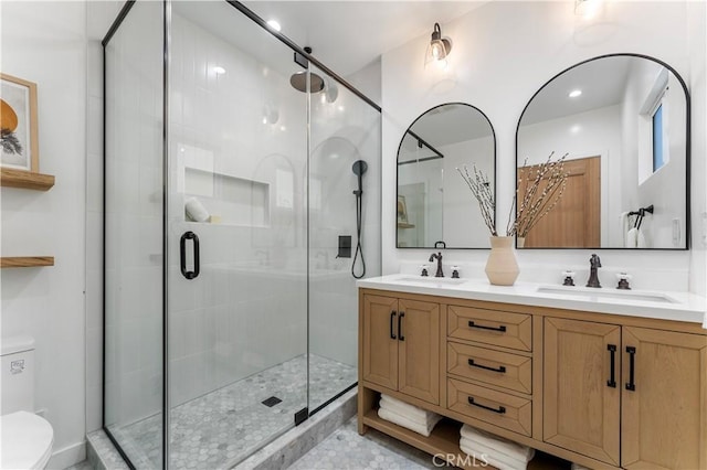 bathroom with vanity, toilet, and a shower with door