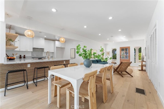 dining area featuring light wood-type flooring and sink