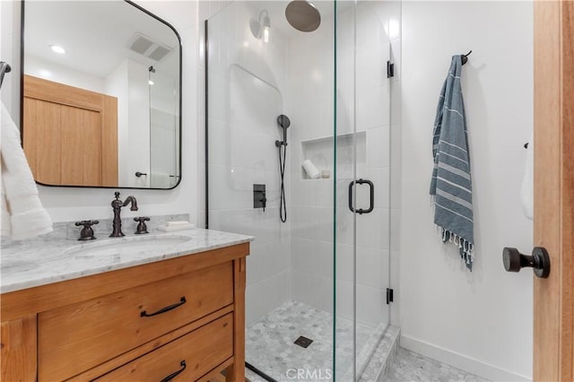 bathroom featuring vanity and a shower with door