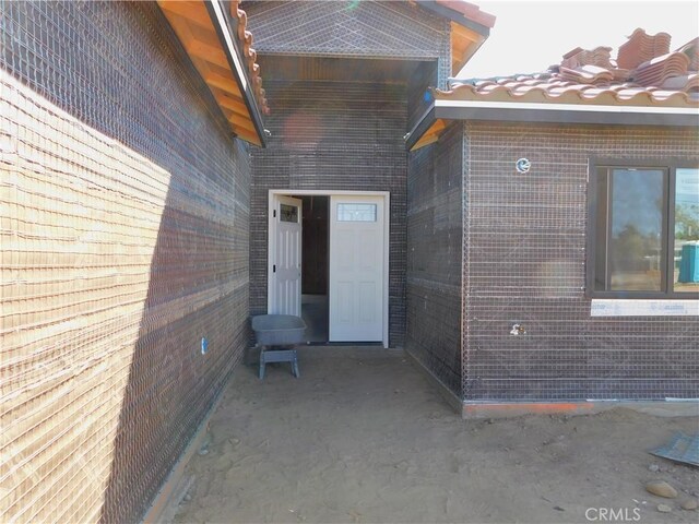 view of exterior entry with a patio