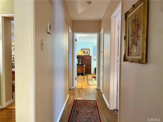 corridor with hardwood / wood-style floors