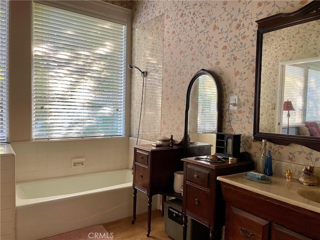 bathroom with plenty of natural light, a bathtub, and vanity