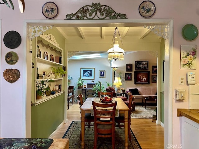 dining space with hardwood / wood-style floors and lofted ceiling with beams