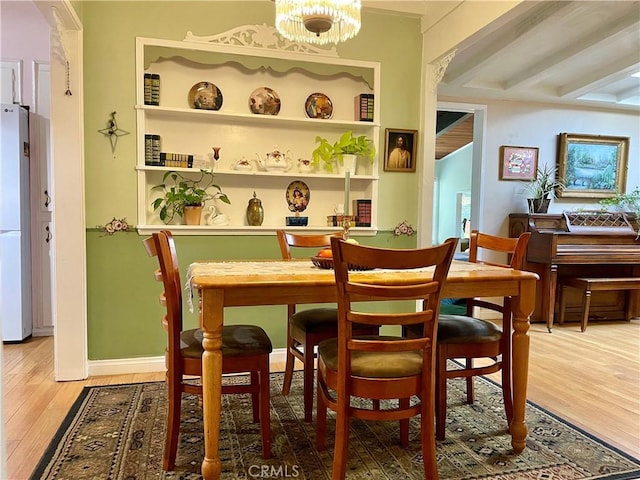 dining area with hardwood / wood-style flooring and an inviting chandelier