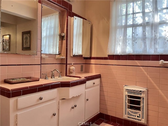 bathroom featuring vanity, decorative backsplash, tile walls, and heating unit