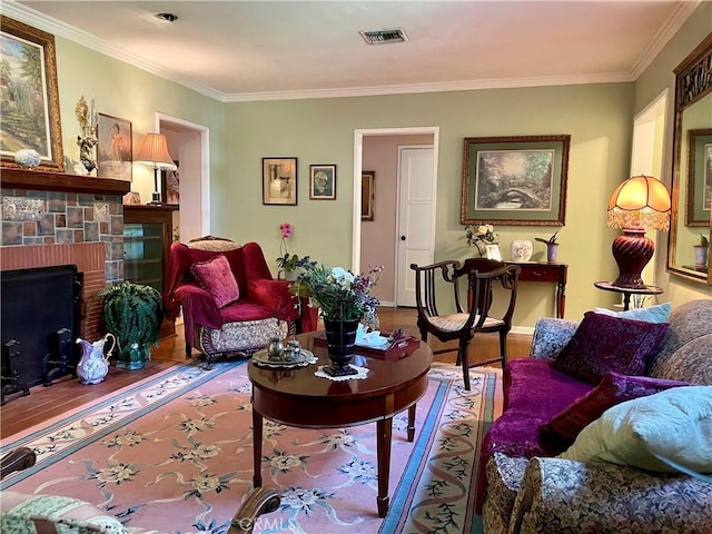 living room with a brick fireplace, hardwood / wood-style flooring, and ornamental molding