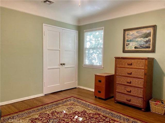 unfurnished bedroom with dark hardwood / wood-style flooring and a closet