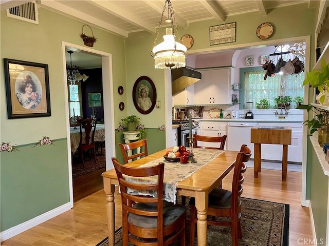 dining room featuring beamed ceiling, light hardwood / wood-style flooring, an inviting chandelier, and wooden ceiling