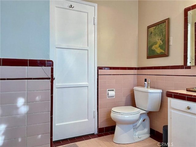 bathroom featuring tile patterned floors, tile walls, and toilet