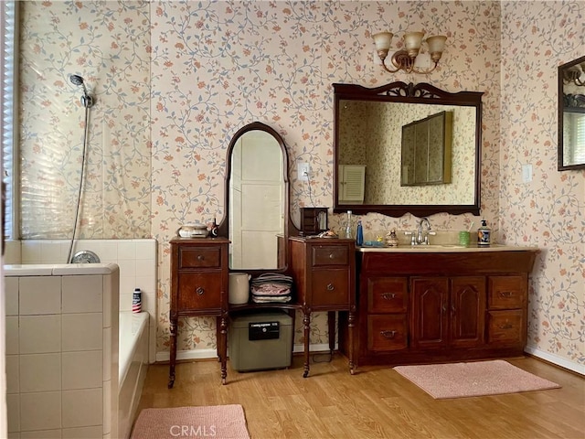 bathroom with a bathing tub, vanity, and wood-type flooring