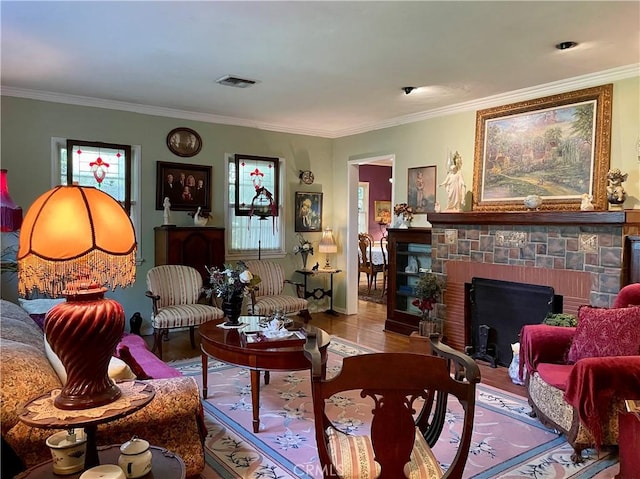 living room with crown molding, hardwood / wood-style floors, and a brick fireplace