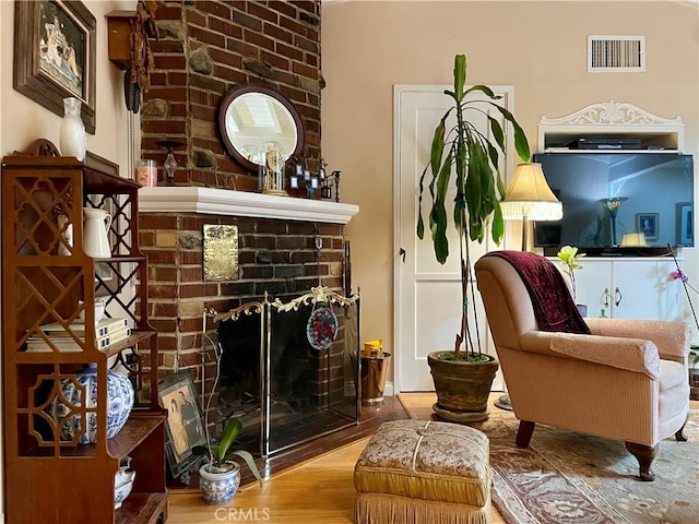 sitting room featuring a fireplace and hardwood / wood-style flooring