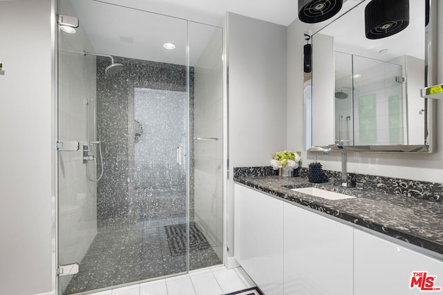 bathroom with an enclosed shower, vanity, and tile patterned floors