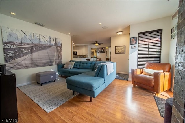 living room with ceiling fan and light wood-type flooring