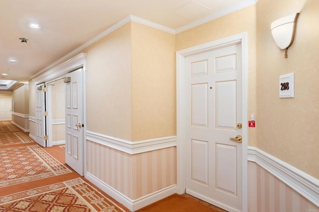 hall with crown molding and a wainscoted wall