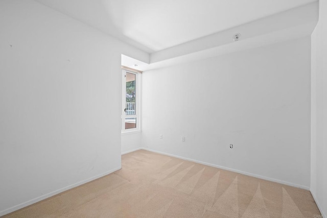 unfurnished room with baseboards and light carpet