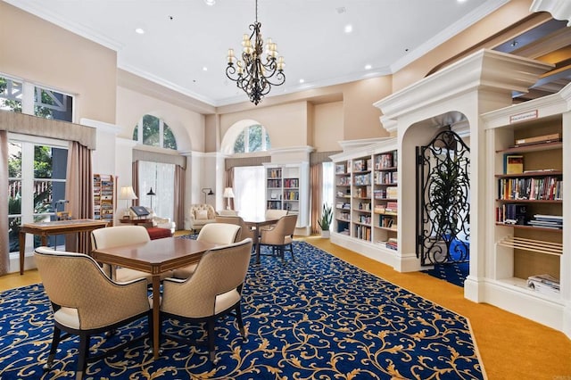 sitting room featuring recessed lighting, crown molding, built in features, a notable chandelier, and a high ceiling