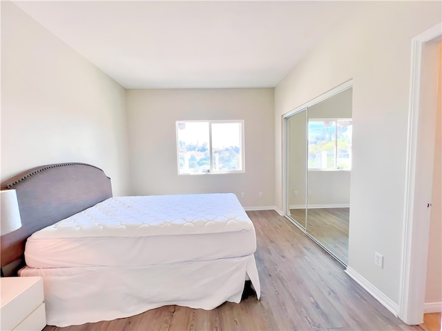 bedroom with light hardwood / wood-style flooring and a closet