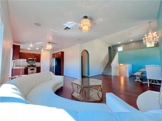 living room featuring dark wood-type flooring and an inviting chandelier