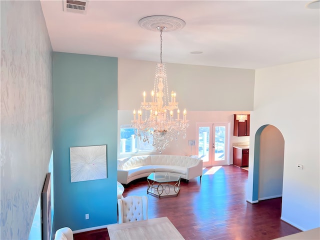 dining space featuring dark hardwood / wood-style floors, a chandelier, and french doors